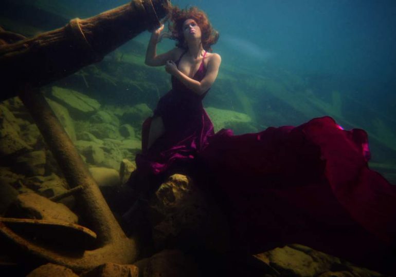 Brave model appears like a real-life mermaid as she poses for world’s deepest photoshoot around shipwreck 100ft under