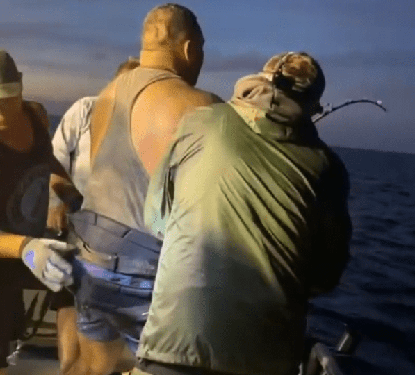 Moment Brit reels in 560lb great white SHARK needing three burly pals to hold him on boat as he heaves beast from depths