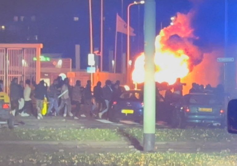 Shocking moment riots erupt in Hague with protesters torching cars as they clash with cops turning city into a warzone