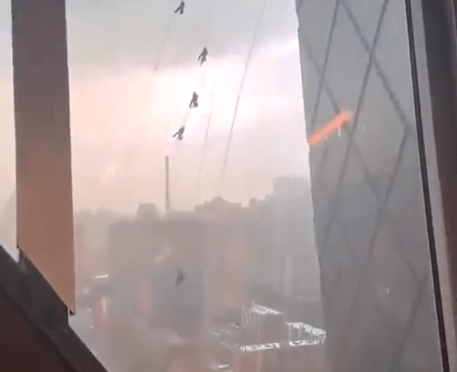 Terrifying moment window cleaners cling on for their lives swinging from 51-storey building as they’re battered by storm