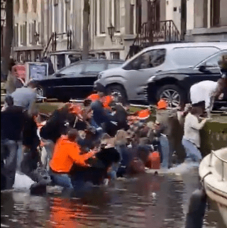 Hilarious moment revellers desperately scramble out of sinking party boat in Amsterdam canal after overcrowding vessel