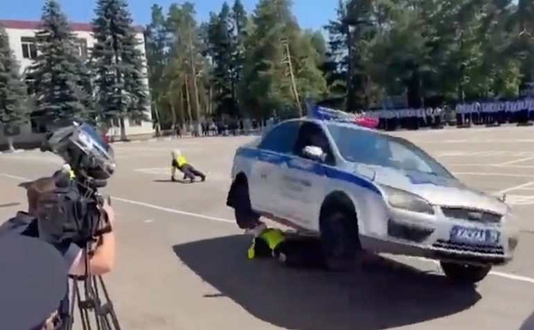 Shock moment police stunt goes horribly wrong as cop is crushed under car & dragged along road in front of shocked crowd