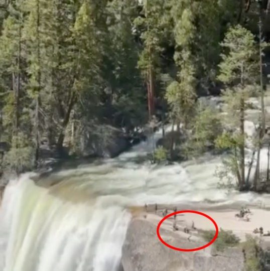 Horror moment reckless tourists jump safety fence to pose for selfies inches from CLIFF edge near notorious waterfall