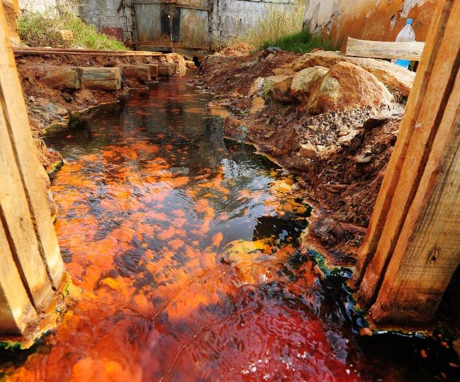 Inside world’s most toxic village swallowed by lake of lethal sludge with only steeple and roofs left above the surface