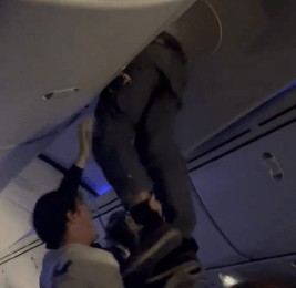 Shocking moment turbulence injures 30 and forces plane to land as passenger has to be removed from overhead locker
