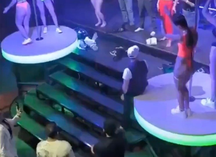 Shocking moment nightclub ravers strip NAKED on stage in front of baying crowd to win an iPhone – before police swoop in