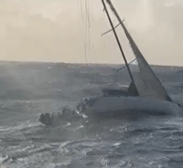 Watch heart-stopping moment couple cling for life to side of yacht after 24 hours being battered by 20ft waves