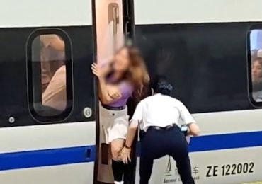 Moment woman wrestles & fights off railway staff to hold up entire train so late pals can board – leading to her ARREST
