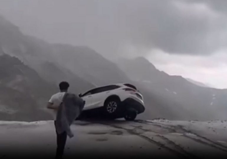 Terrifying moment car dangles precariously over sheer cliff drop sparking frantic mission to save occupants inside