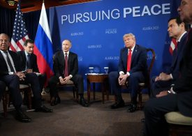 Moment Trump and Putin’s photocall erupts into CHAOS as smirking Vlad tries to shout over journalists before peace talks