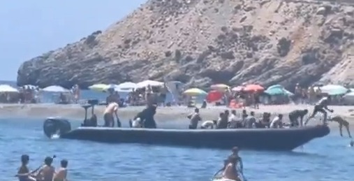 Watch moment migrant boat arrives on Spain hols beach before they are chased & tackled by angry locals