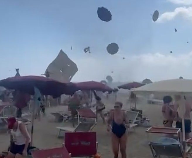 Shock moment tourists flee as TORNADO smashes into Italian beach sending parasols flying into the air