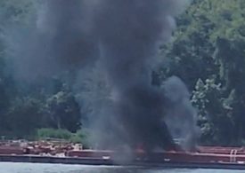 Helicopter crashes into barge killing two after hitting powerlines as burned-out wreck left on boat