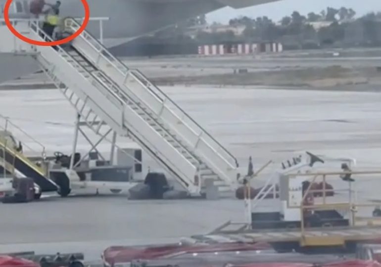 Spanish airport worker filmed hurling bags from plane like an Olympic athlete sparking outrage… but is all as it seems?