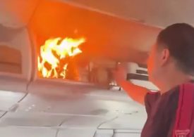 Moment flames erupt in plane cabin after battery in overhead luggage combusts as flight forced to make emergency landing