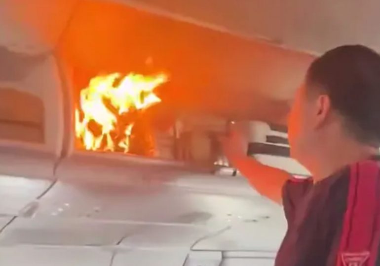 Moment flames erupt in plane cabin after battery in overhead luggage combusts as flight forced to make emergency landing