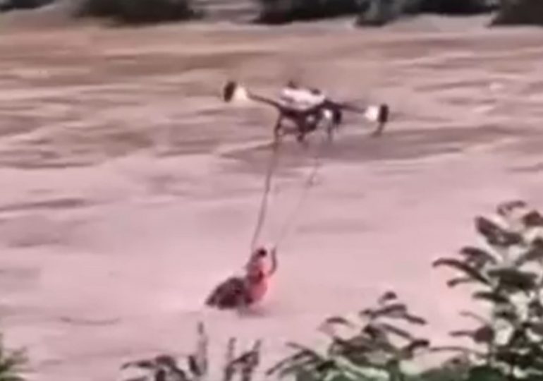 Watch incredible moment drone saves man from drowning in river as relentless flooding submerges houses and kills 55