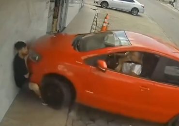 Horror moment driver presses the wrong pedal while parking and smashes into bystander crushing him against the wall
