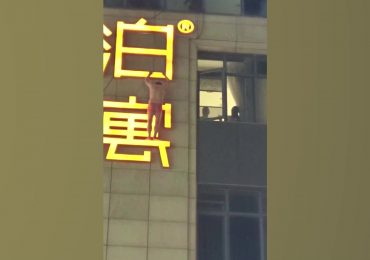 Shocking moment ‘secret lover’ dangles from hotel sign in just boxers after ‘escaping out window to avoid being spotted’