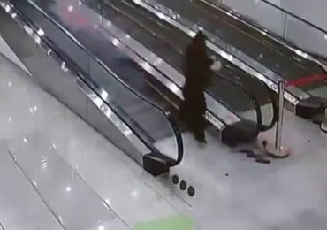 Shock moment lazy supermarket worker wipes customer out with stack of trolleys after trying to push them down escalator