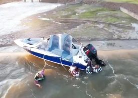 Horror moment four men cling to boat on edge of 130ft dam as rescuers race against time to save them