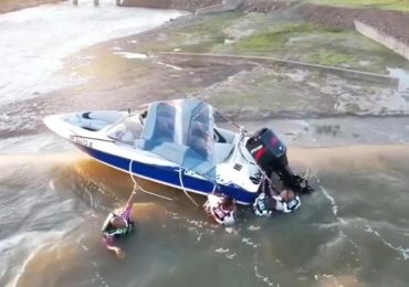 Horror moment four men cling to boat on edge of 130ft dam as rescuers race against time to save them