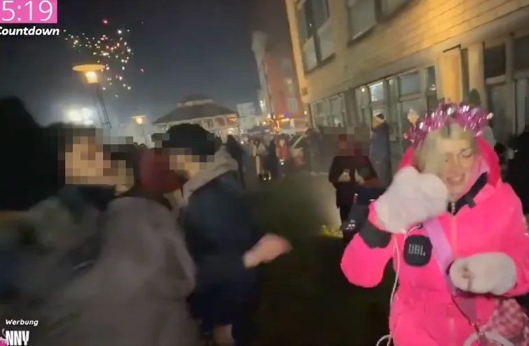 Shocking moment influencer is attacked TWICE & hit with ‘firework’ as wild NYE street parties descend into total anarchy