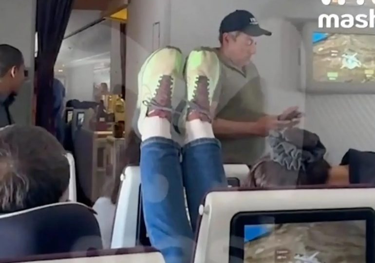 Shock moment plane passenger from hell rests her FEET on headrest in act of revenge after fellow flier reclined her seat