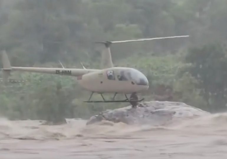 Moment hero pilot saves couple marooned on rock in raging river after being stranded for 27 hours in floodwaters