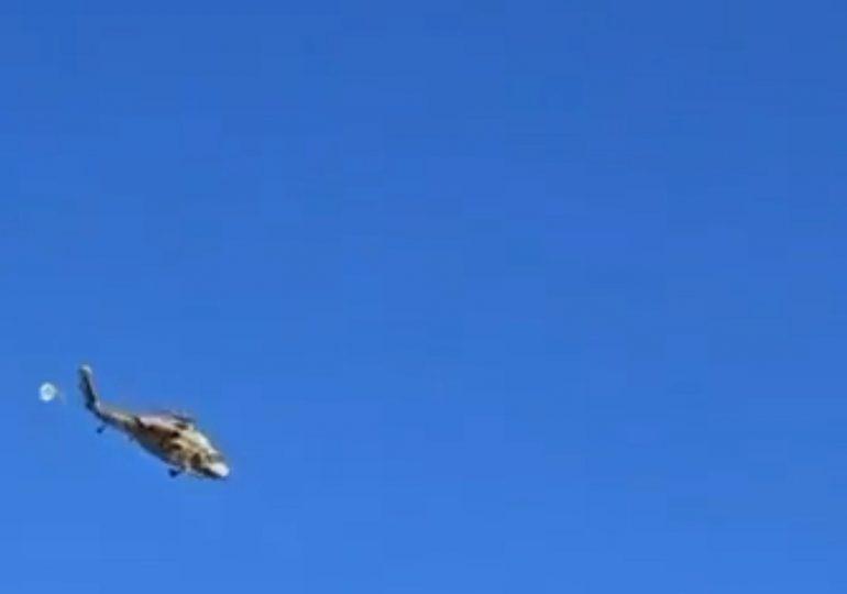 Terrifying moment helicopter being flown by second chopper breaks free and falls to the ground after harness failed