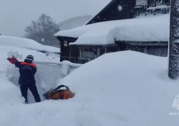 Entire buildings buried in MASSIVE snow drifts as mega blizzards kill at least two and locals forced to dig out of homes
